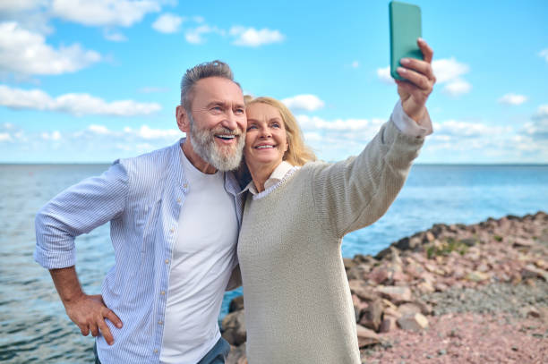 istock Woman with smartphone taking selfie with man 1342474142