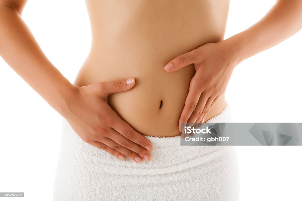 Woman with both hands on belly wearing towel below waist Slim woman  Abdomen Stock Photo