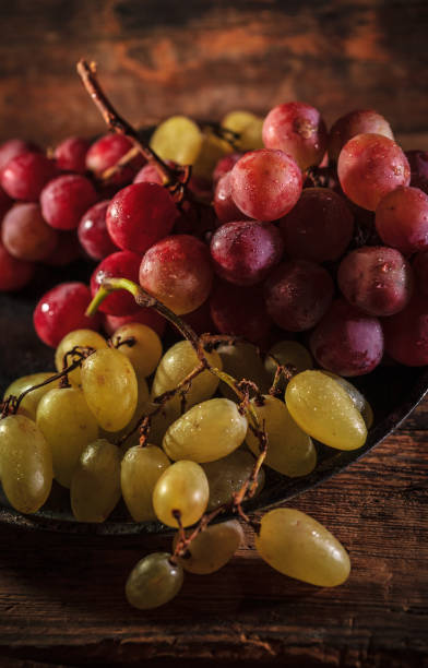 istock Fresh red and green organic grapes on wooden table, selective focus 1342479440