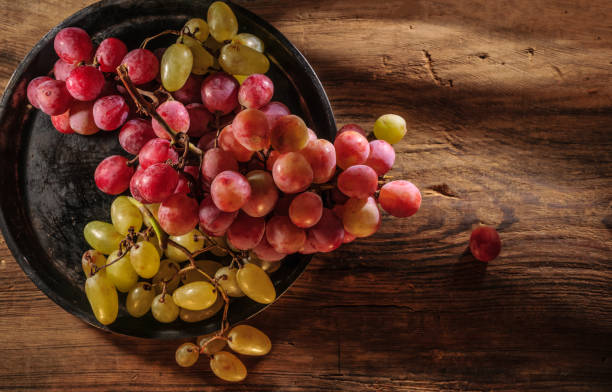 istock Fresh red and green organic grapes on wooden table, selective focus 1342479457