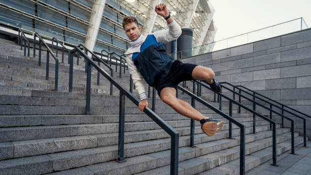 concentrated sporty man jumps over the railing - determination running staircase jogging imagens e fotografias de stock