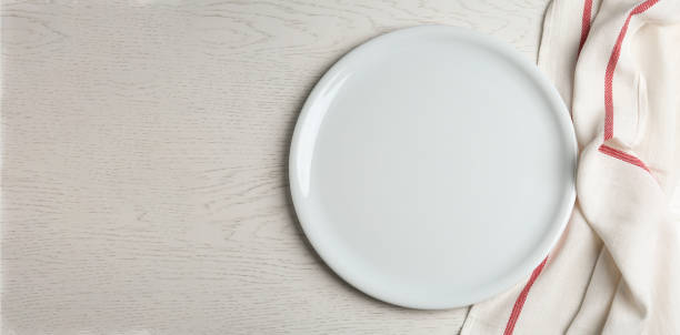 istock Empty plate and fabric on white wooden table, flat lay 1342480835