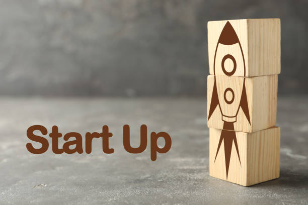 istock Rocket made of wooden cubes and text START UP on grey background 1342481606