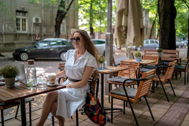 istock Businesswoman using laptop while enjoying work at cafe table with cup of coffee 1342481827