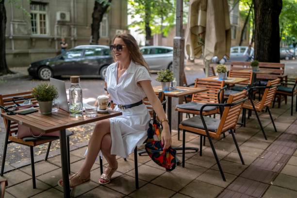 istock Businesswoman using laptop while enjoying work at cafe table with cup of coffee 1342481834