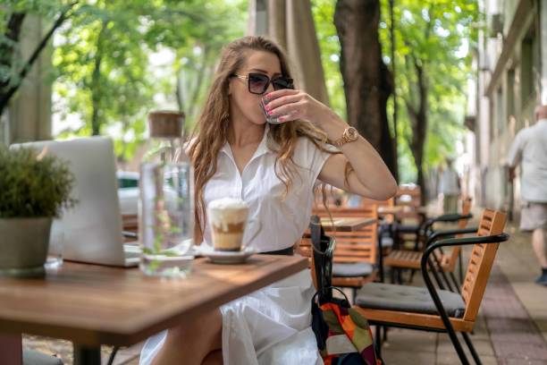 istock Businesswoman using laptop while enjoying work at cafe table with cup of coffee 1342481840