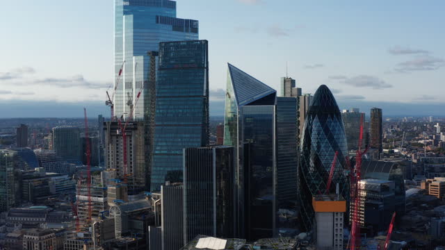 Slide and pan footage of futuristic office buildings in City. Gherkin, Scalpel and other iconic modern skyscrapers. London, UK