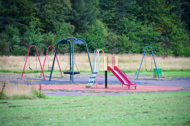 empty playground derelict swings and slide in rural area - swing playground empty abandoned imagens e fotografias de stock