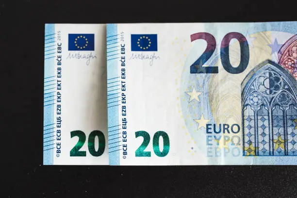 Banknotes on a black background - two banknotes of 20 euros symbolize the concept of 2020