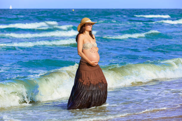 istock Pregnant woman on the beach with waves 1342487972