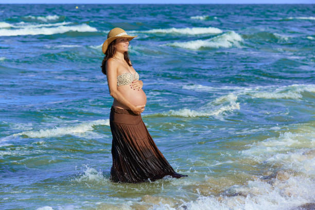 istock Pregnant woman on the beach with waves 1342487977