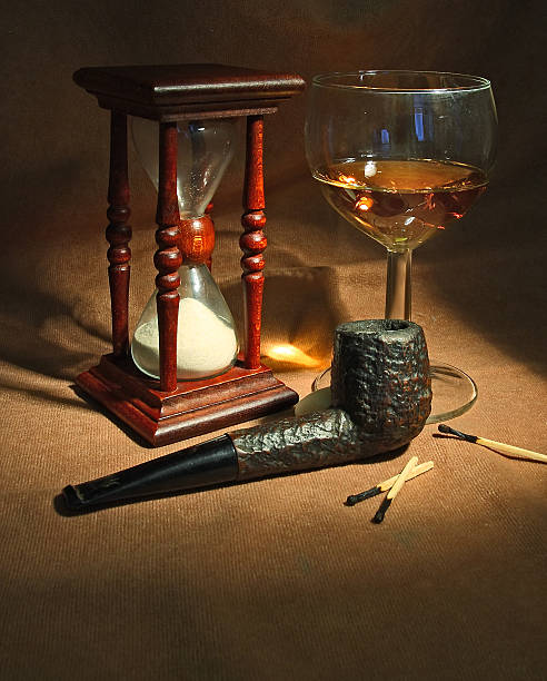 Tobacco pipe, glass of whiskey and sandglass stock photo