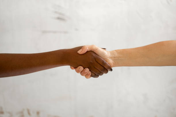 istock Close up of two diverse unrecognizable persons holding hands 1342495836