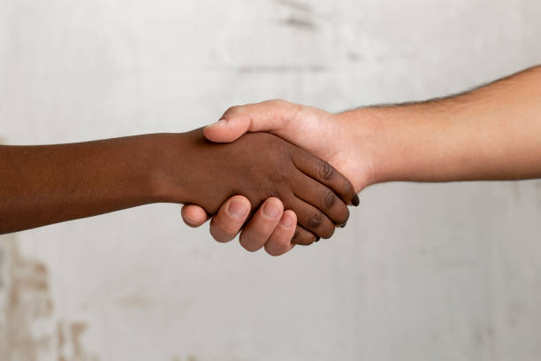 istock Close up of two diverse unrecognizable persons holding hands 1342495910