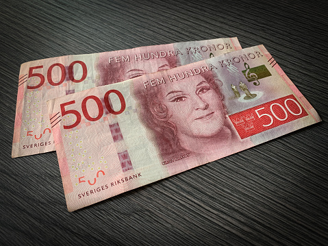Swedish krone bills isolated on dark wooden background. Close up 500 fem hundra kronor.