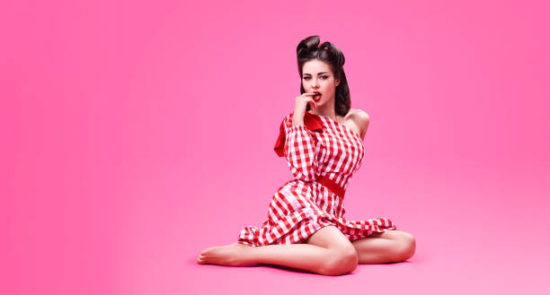 Beautiful young brunette dressed in retro style emotionally bites her finger stock photo
