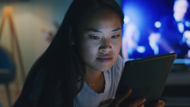 istock Asian female watching video on tablet in evening 1342503557