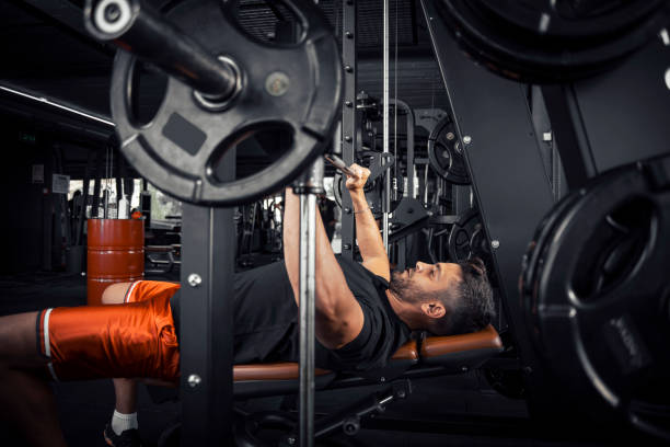 Man doing bench press exercise at gym stock photo