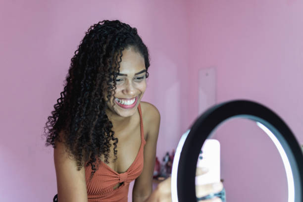 joven negra filmándose a sí misma bailando en casa para compartir en las redes sociales - tiktok fotografías e imágenes de stock