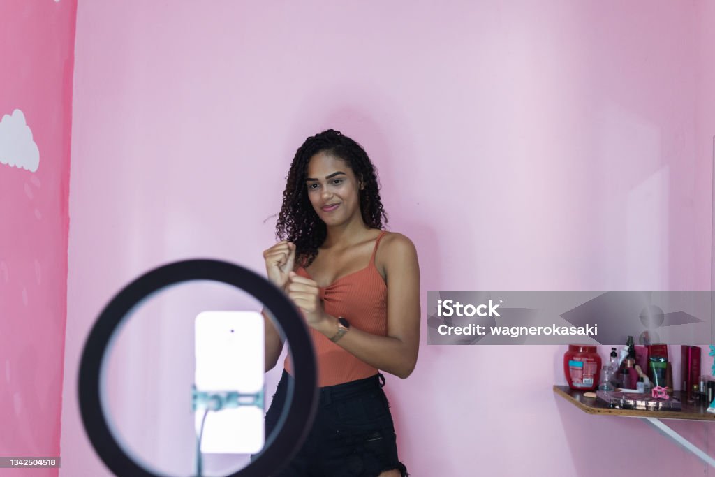 Black young woman filming herself dancing at home to share on social media Viral Video Stock Photo