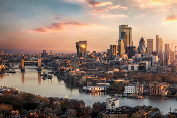 the skyline of london city with tower bridge and financial district during sunrise - tower bridge stockfoto's en -beelden