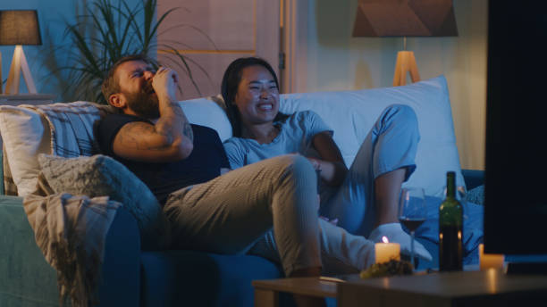 istock Diverse couple watching comedy film in evening 1342505905