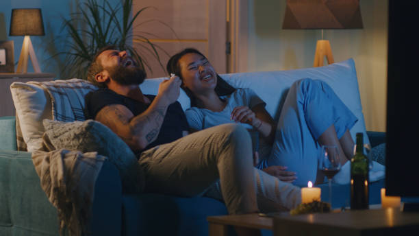 istock Diverse couple watching comedy film in evening 1342506539