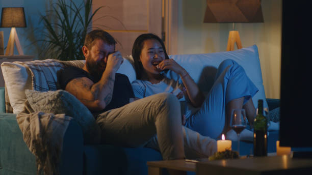 Diverse couple watching comedy film in evening