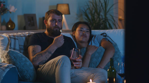 istock Multiracial couple watching TV during date 1342507625