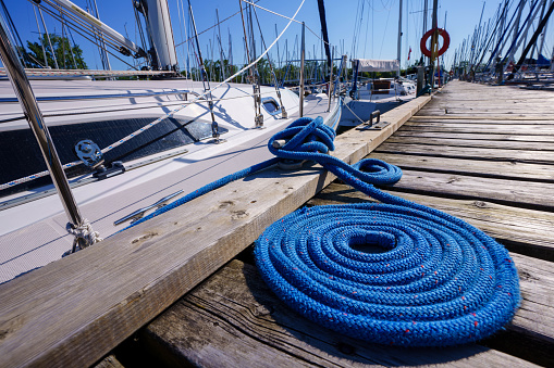 Boat Rope Secured To Cleat On Wooden Dock