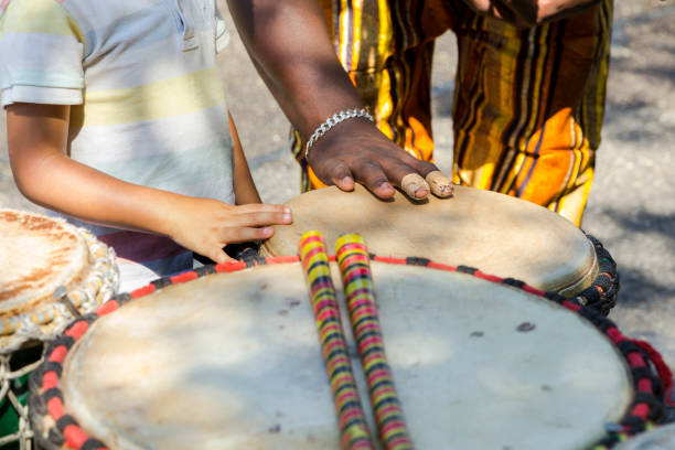 Close up of hands of a black man playing a jembe