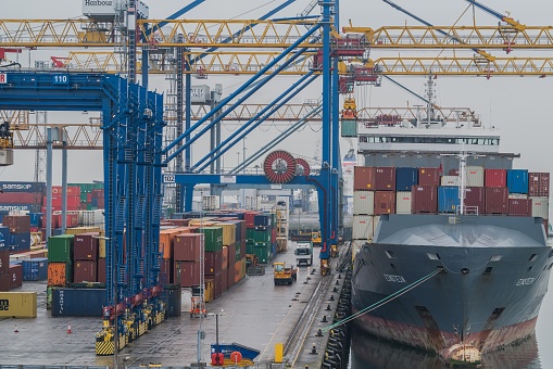 Belfast, United Kingdom - September 15, 2021: Cranes, cargo containers and ship at a commercial dock within Belfast Harbour.