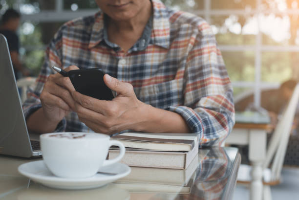 istock Man working on laptop computer and smartphone at cafe 1342528554