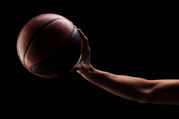giocatore di basket professionista che tiene una palla su sfondo nero - streetball basketball sport men foto e immagini stock