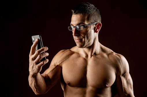 Bodybuilder checking his smart phone