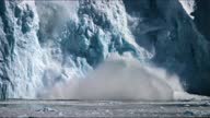 istock Iceberg begins to crumble throwing spray and waves up in its monstrous wake. 1342578498