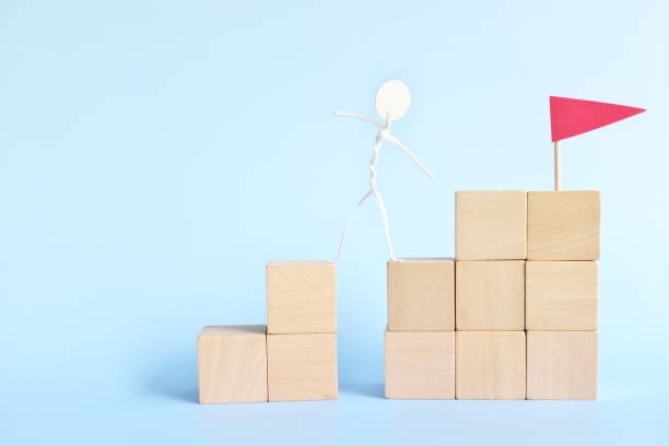 istock Conquering adversity, overcome challenge and obstacle and taking risk to success concept. Human stick figure crossing and climbing broken ladder with red flag. 1342584193
