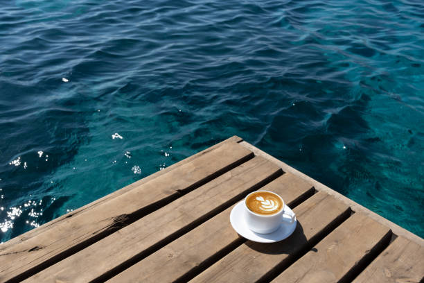 coffee cup on wooden floor by the beach