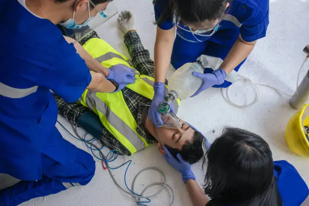 Paramedic man and team CPR and use ambu bag help unconscious worker accident in construction site.