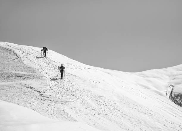 two hikers on a trail walking through snow. winter landscape in carapathian mountains, romania. - on top of mountain peak success cold imagens e fotografias de stock