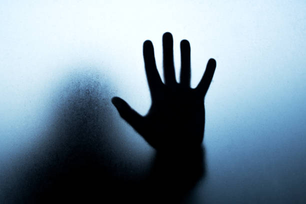 istock Hand black silhouette behind misted glass in shadows 1342605409