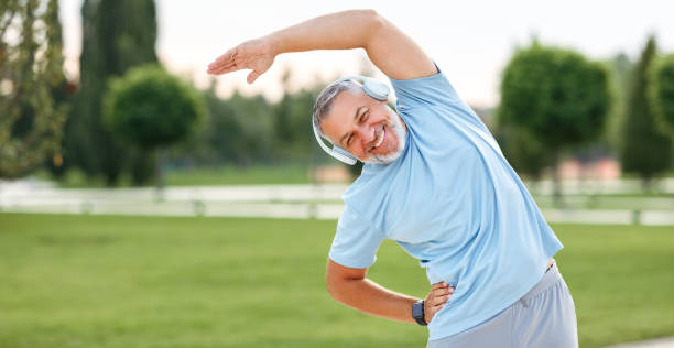 istock Happy retired senior man doing side stretching exercises with arm overhead during outdoor workout 1342605863