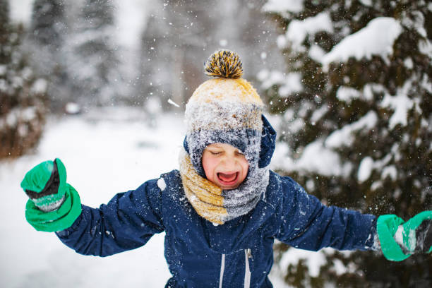 istock Little boy playing with snow in park 1342607605