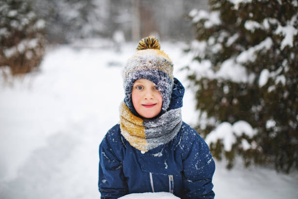 istock Little boy playing with snow in park 1342607618