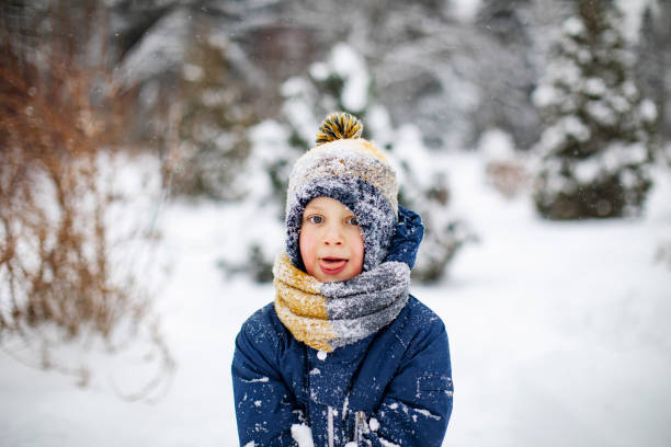 istock Little boy playing with snow in park 1342607629
