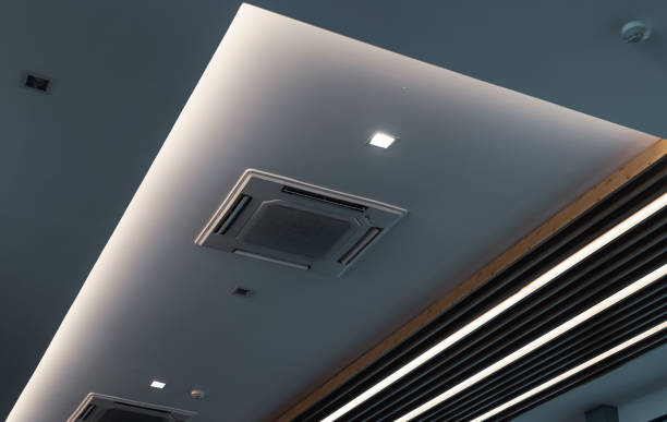 istock Selective focus on cassette type air conditioner mounted on ceiling wall. Air duct on ceiling in hotel. Air heading unit on gypsum wall. Cool system in the building. Air flow and ventilation system. 1342608991