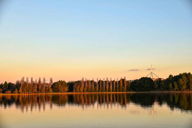 Sunset on the lake with trees reflection in the water.