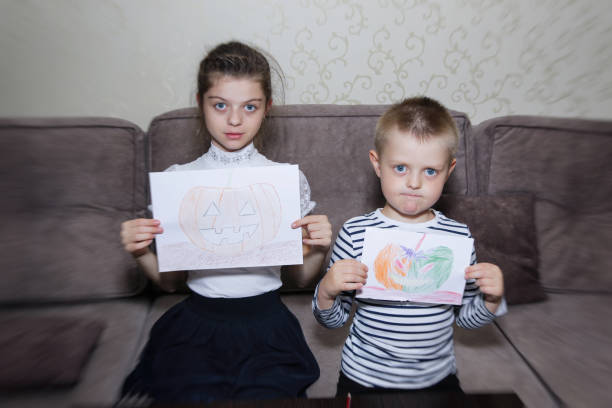istock Children draw drawings of pumpkins on sheets 1342621019