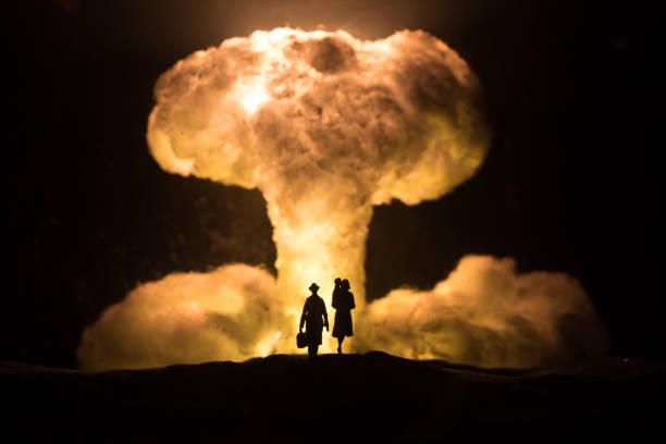 Nuclear war concept. Explosion of nuclear bomb. Creative artwork decoration in dark. Family standing against giant mushroom cloud of atomic explosion. Selective focus