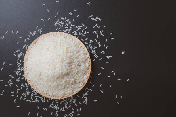 Hand holding jasmine rice. jasmine rice on wooden plate. farmer's produce. Asian food. Hand holding jasmine rice. jasmine rice on wooden plate. farmer's produce. Asian food. jasmine rice stock pictures, royalty-free photos & images